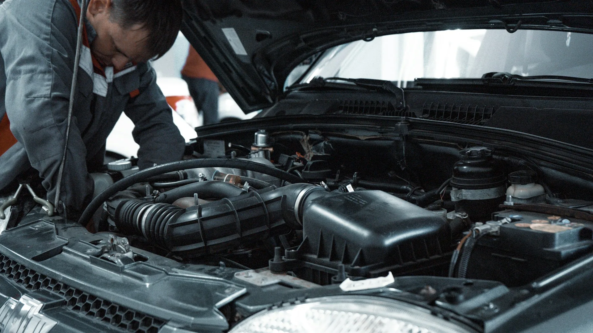 Mecânico inspecionando cuidadosamente o motor de um carro